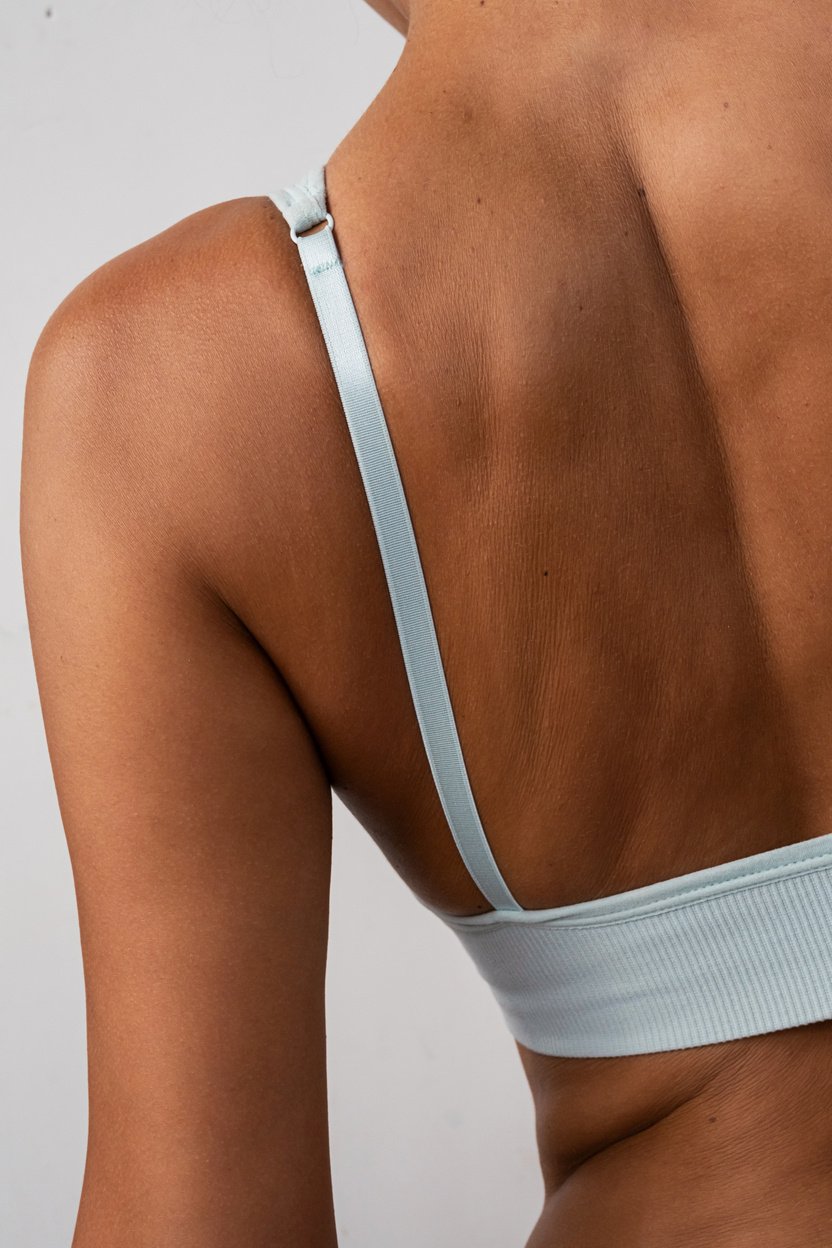 Woman's back. Tanned females torso wearing bra.